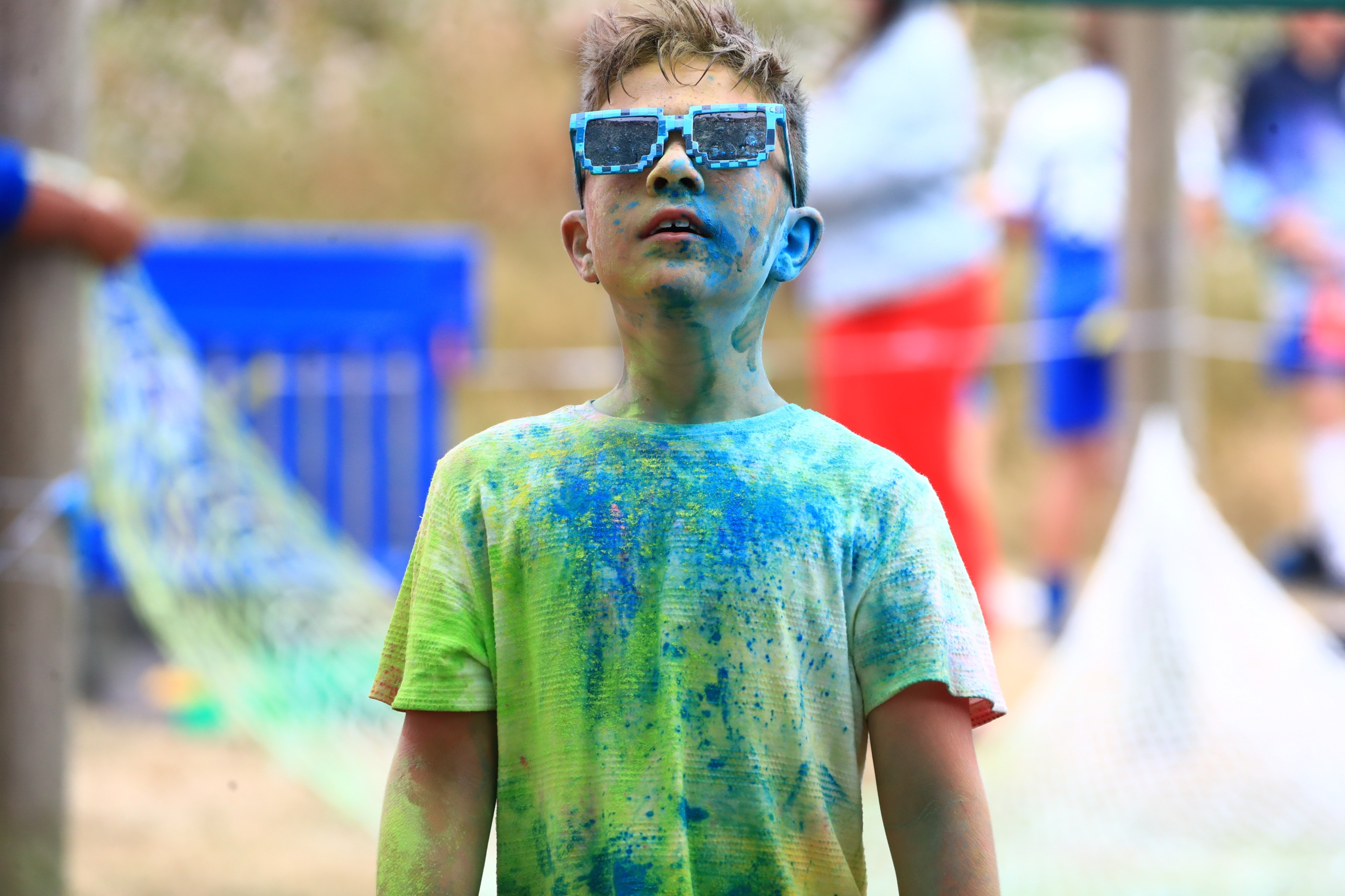 Young participant wearing colourful glasses at a community event